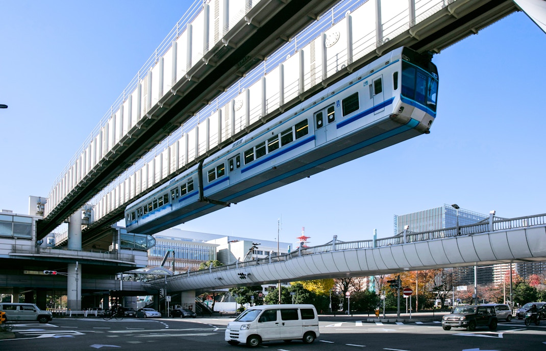 Suspended monorail train traveling above a street in Chiba, Japan.