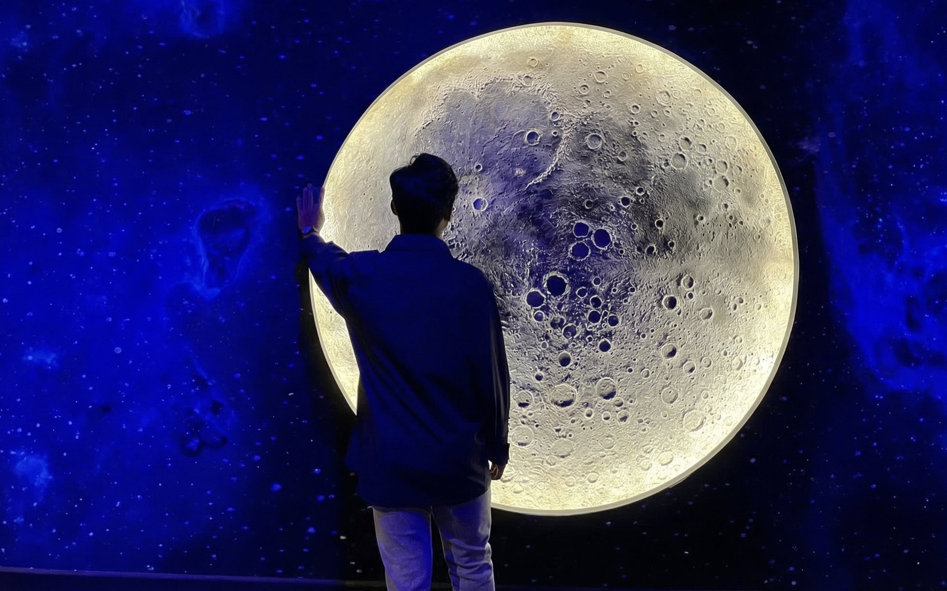 Child posing in front of a moon exhibit at Petrosains, The Discovery Centre, Kuala Lumpur.