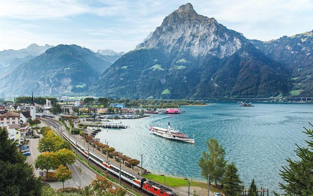 Train and boat on Lake Lucerne with Swiss Alps in the background.