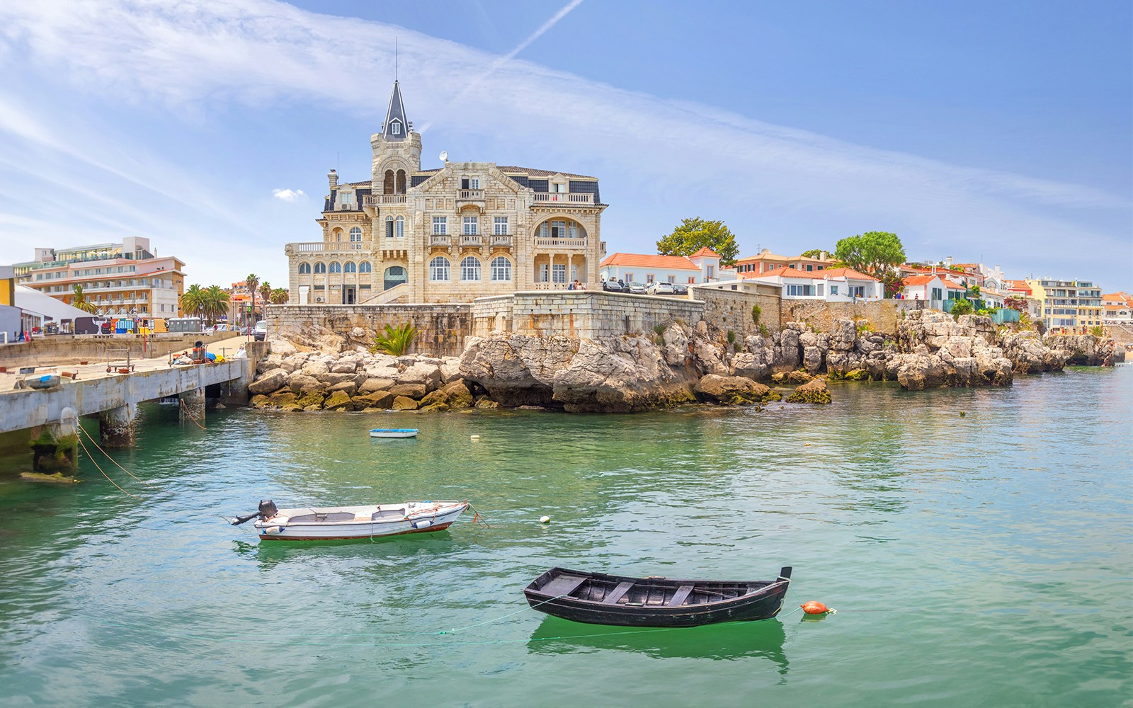Seixas Palace in Cascais with boats on the water in the foreground.