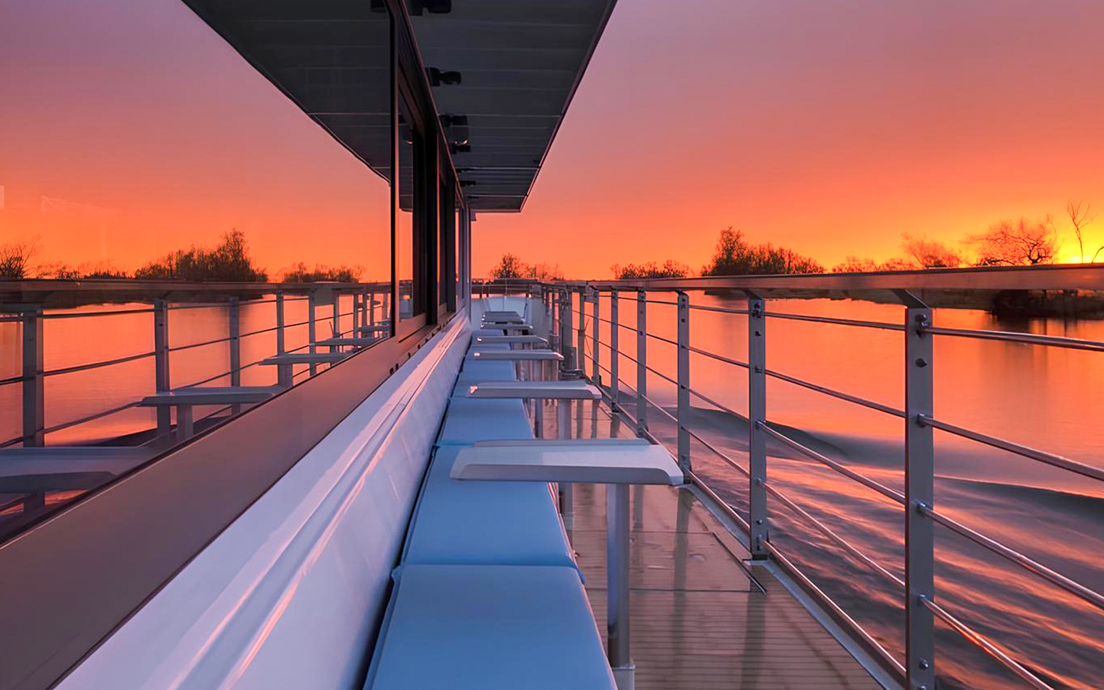 Berlin evening cruise deck with sunset reflecting on the water.