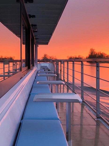 Berlin evening cruise deck with sunset reflecting on the water.