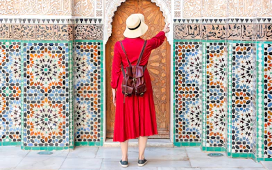 Lady admiring intricate tilework at Ben Youssef Madrasa, Marrakesh, Morocco.