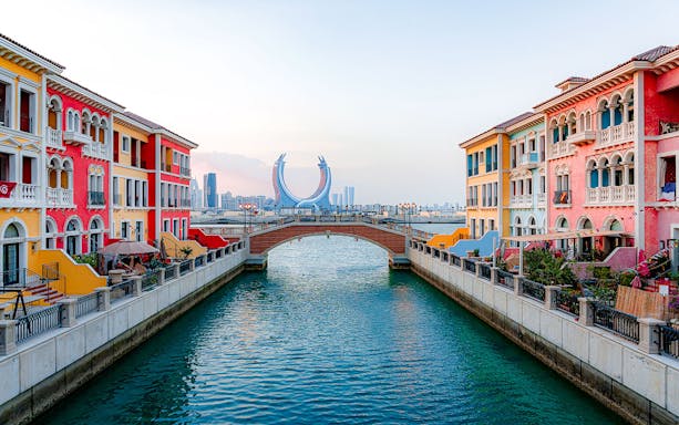 Colorful buildings and a bridge over a canal at The Pearl Island, Qatar.