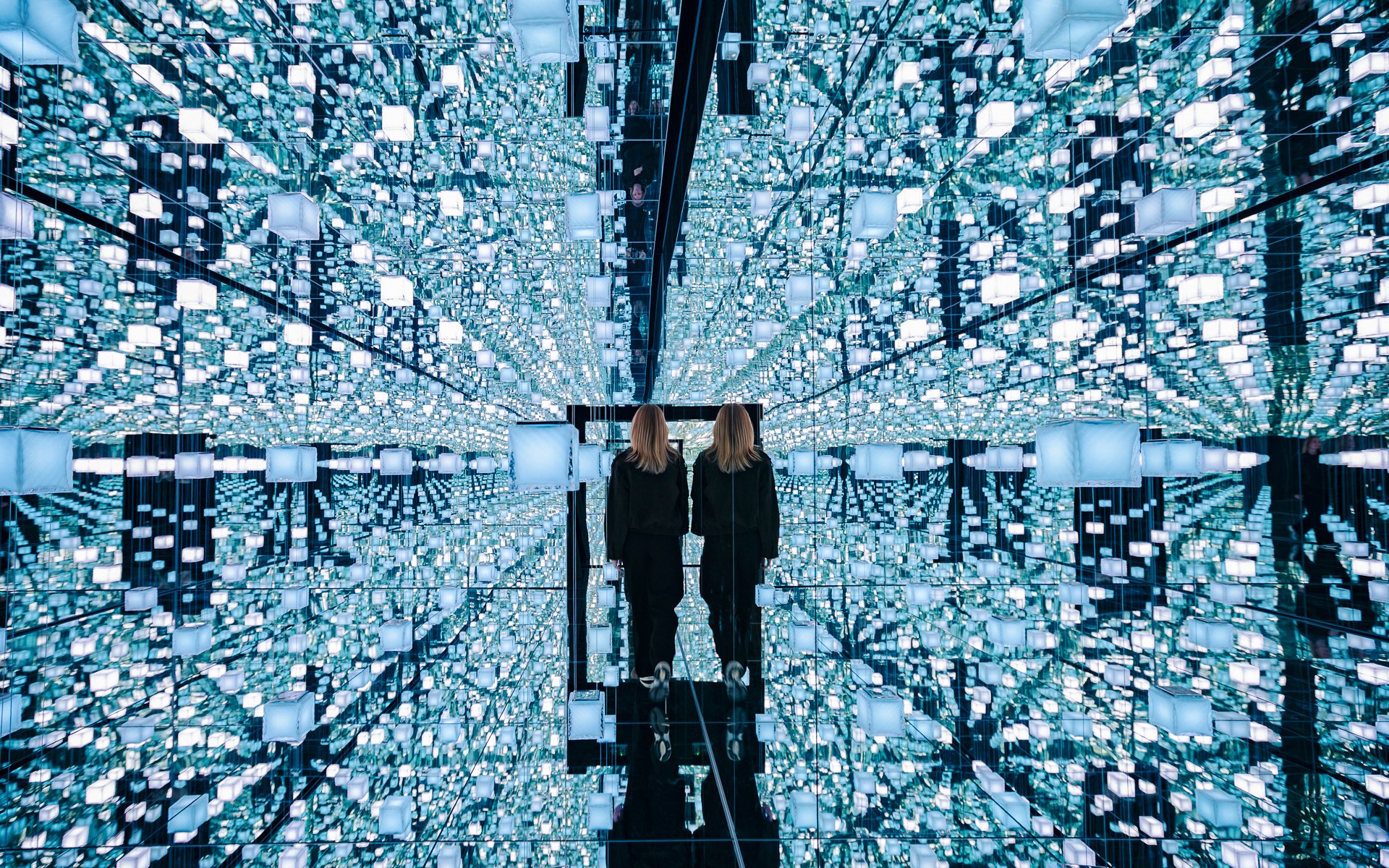 Guests exploring mirrored digital art installation at Signal Space Digital Art Gallery.