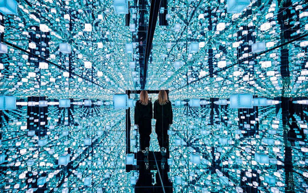Guests exploring mirrored digital art installation at Signal Space Digital Art Gallery.