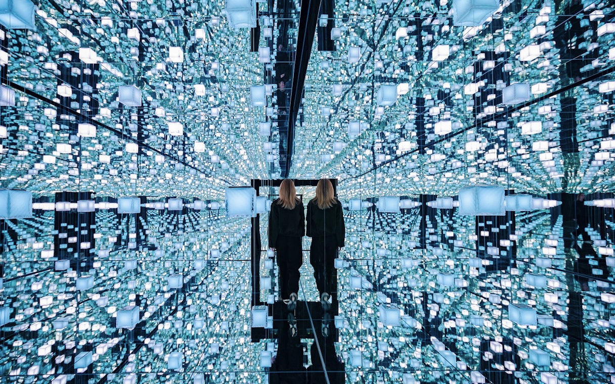 Guests exploring mirrored digital art installation at Signal Space Digital Art Gallery.