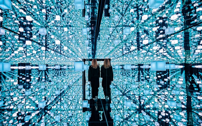 Guests exploring mirrored digital art installation at Signal Space Digital Art Gallery.