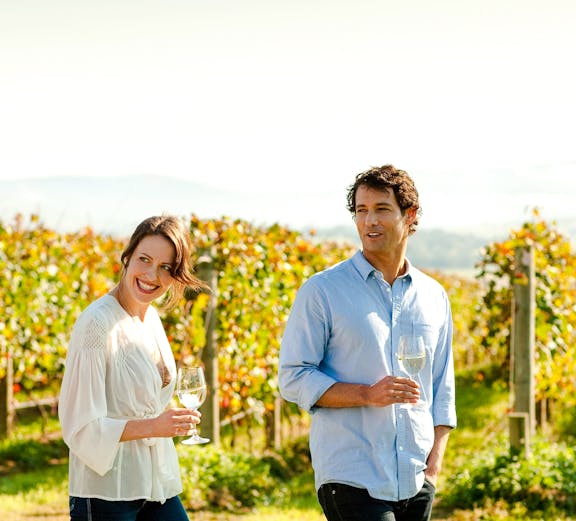 Couple enjoying wine in Yarra Valley vineyard.