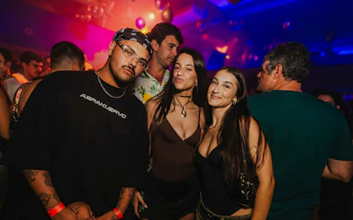 Partygoers enjoying Lunes de Perreo event in Rio de Janeiro nightclub.
