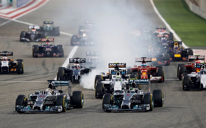 Formula 1 cars racing on track at Malaysia Grand Prix.