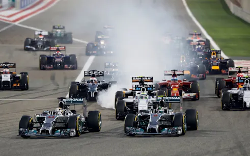 Formula 1 cars racing on track at Malaysia Grand Prix.