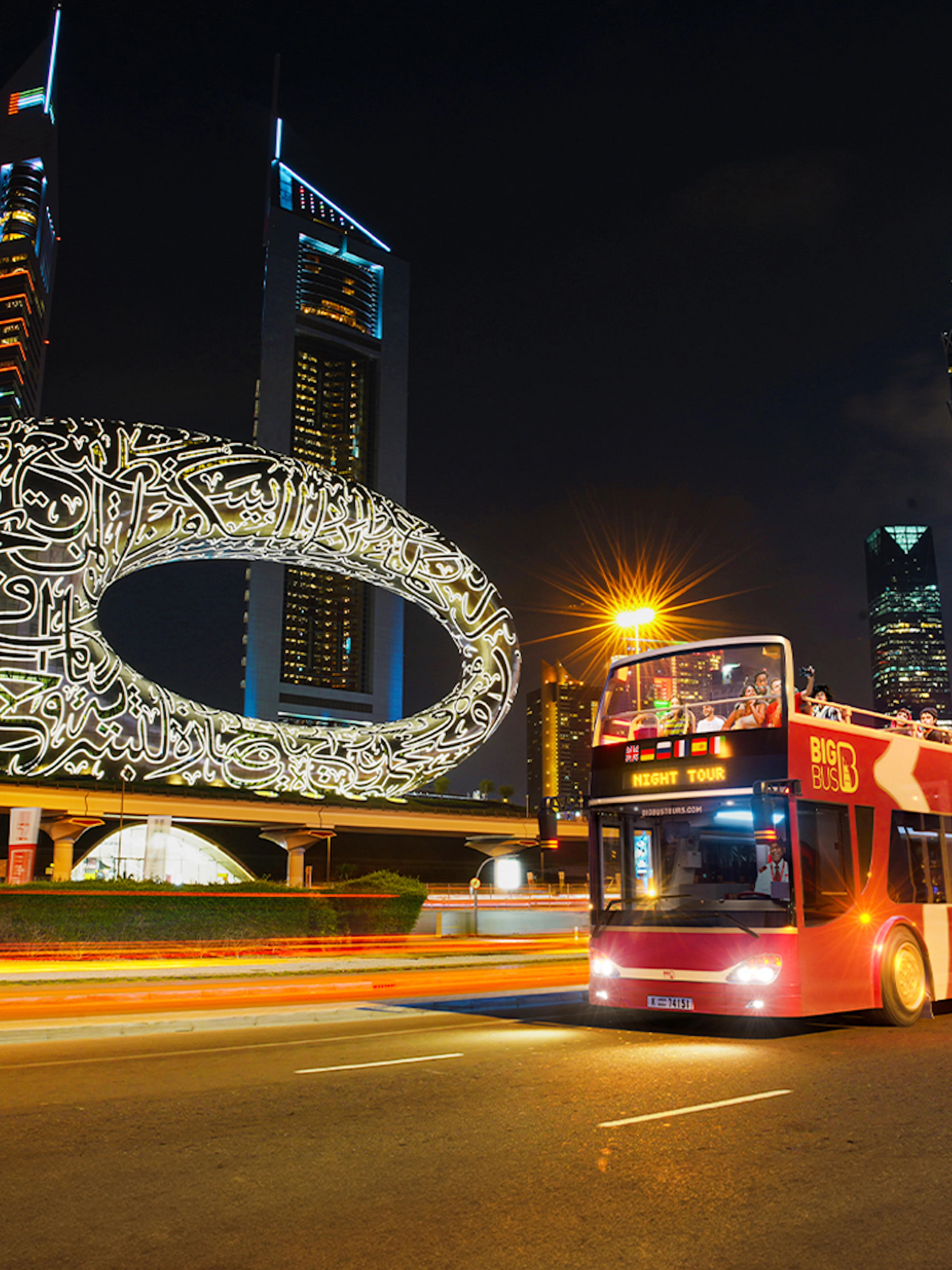 Big Bus Dubai Night Tour passing the Museum of the Future and skyscrapers.