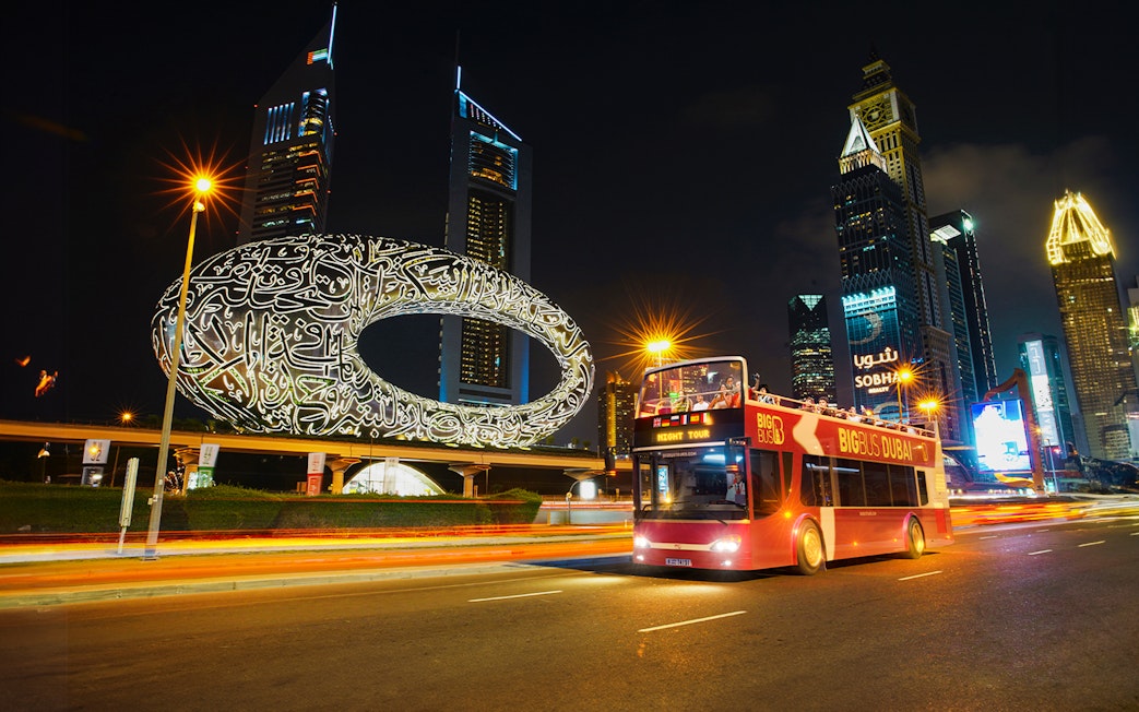 Big Bus Dubai Night Tour passing the Museum of the Future and skyscrapers.