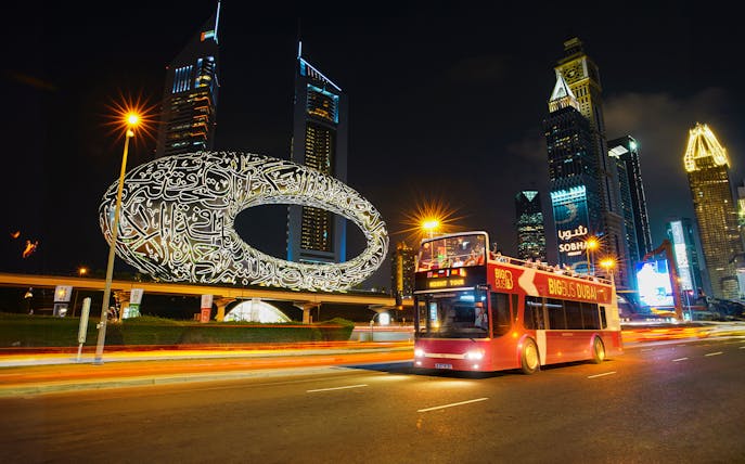 Big Bus Dubai Night Tour passing the Museum of the Future and skyscrapers.