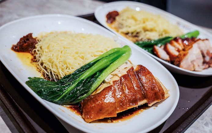 Noodles with roasted chicken and greens at a Michelin-starred restaurant.