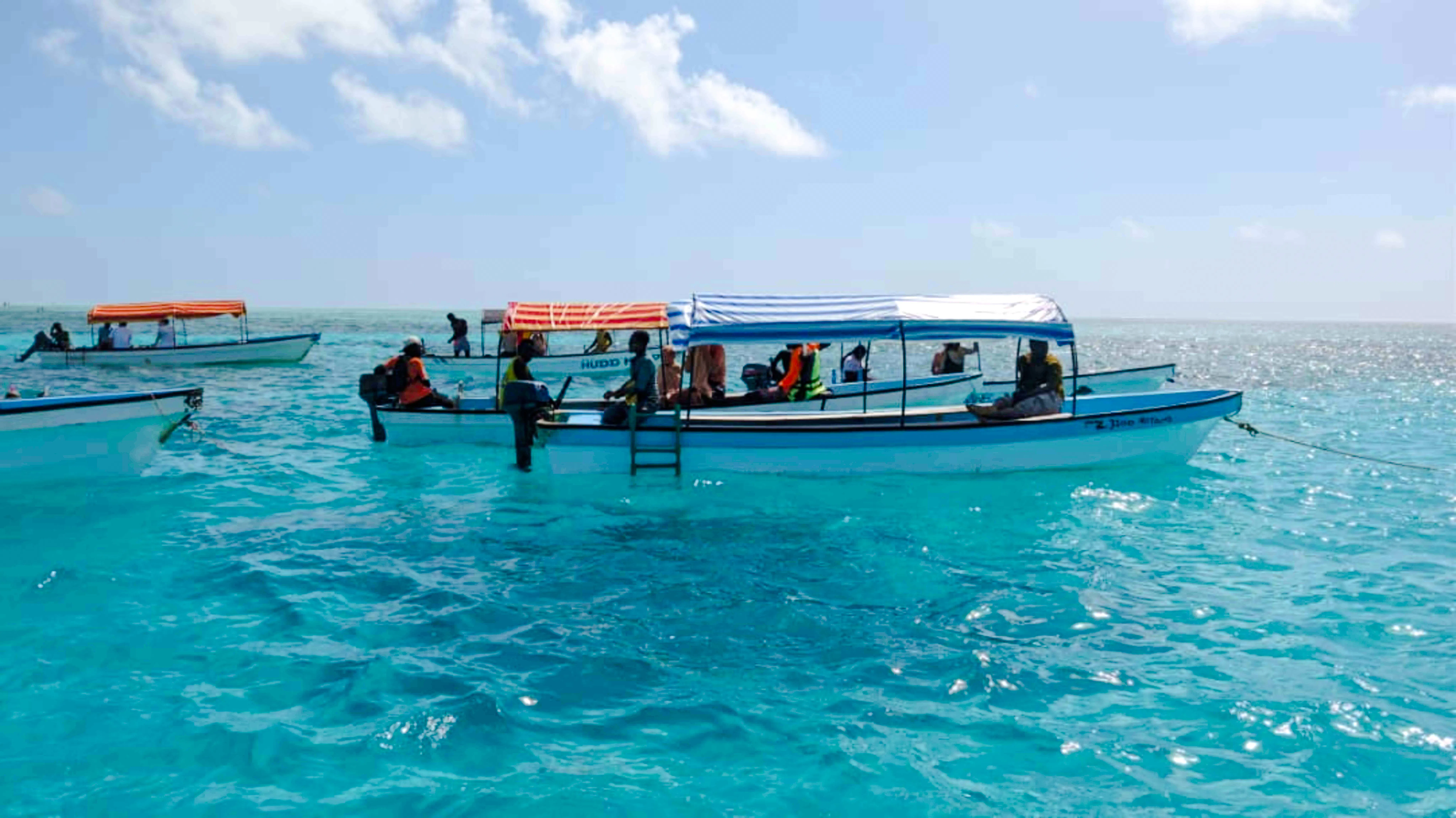 Boats with tourists preparing for snorkeling near Mnemba Island, Zanzibar.