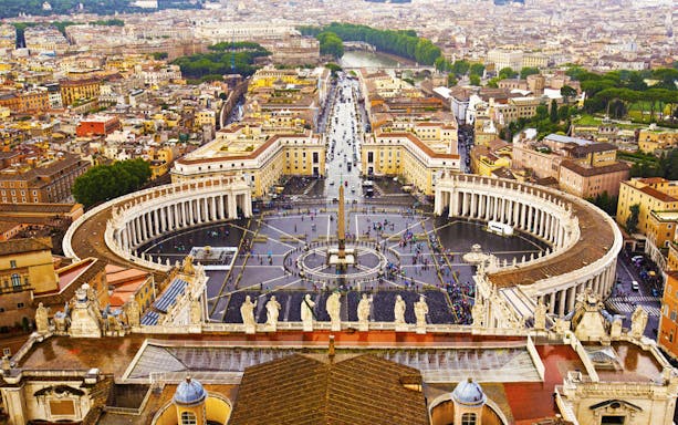Aerial view of St. Peter's Square in Vatican City, Rome, with surrounding architecture.
