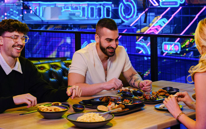 Dining experience at Loco Lounge, Loco Bear, Dubai with neon lights in the background.