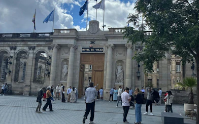 Hôtel de Ville in Bordeaux with people gathered for a self-guided city exploration game.