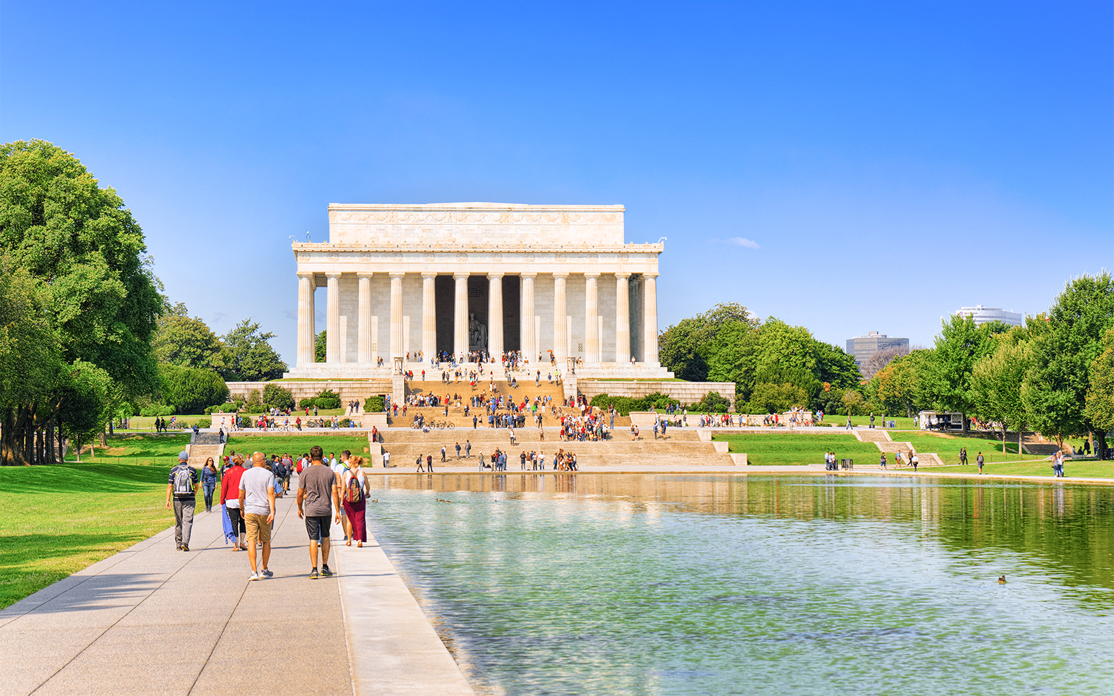 Lincoln Memorial with visitors, Washington, USA, reflecting pool in foreground.