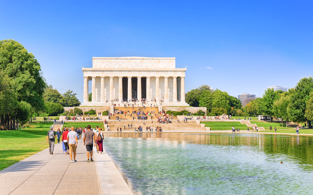 Lincoln Memorial with visitors, Washington, USA, reflecting pool in foreground.