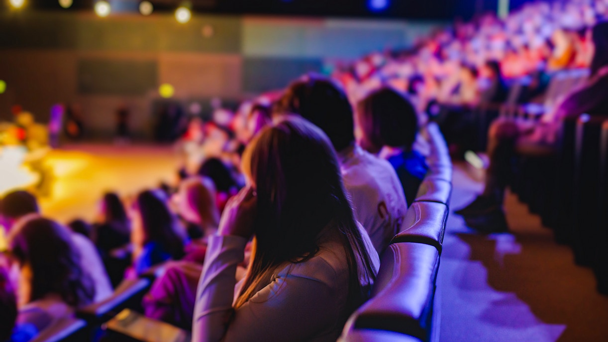 Audience seated at an amphitheatre during a live performance.
