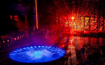 Performers on stage with water effects during La Perle show, Red Sea theme.