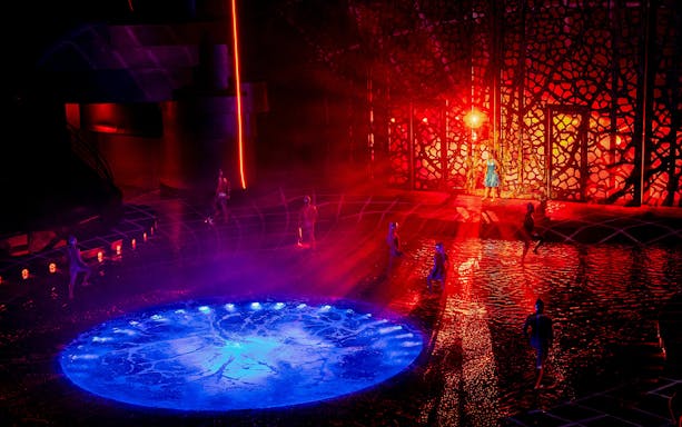 Performers on stage with water effects during La Perle show, Red Sea theme.