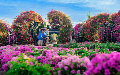 Visitors enjoying vibrant floral arches at Nong Nooch Tropical Garden.