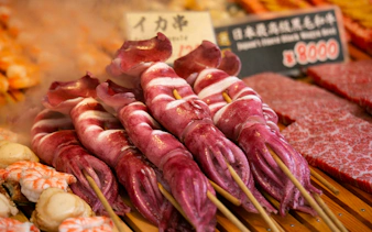 Skewered squid at a food stall in Tsukiji Outer Market, Tokyo, Japan.