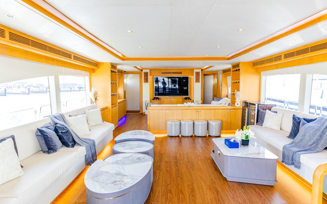 Luxurious yacht interior with spacious seating, modern decor, and large windows.