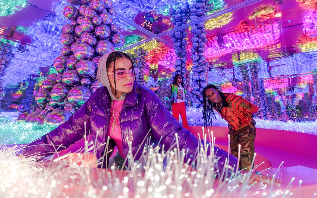 Visitors exploring vibrant, mirrored room at House of Hype.