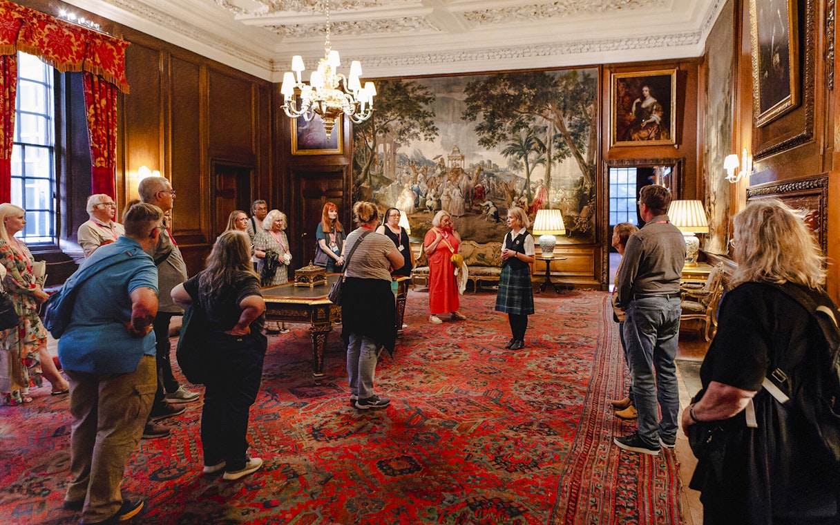 Guided group tour inside the ornate room of Palace of Holyroodhouse, Edinburgh.