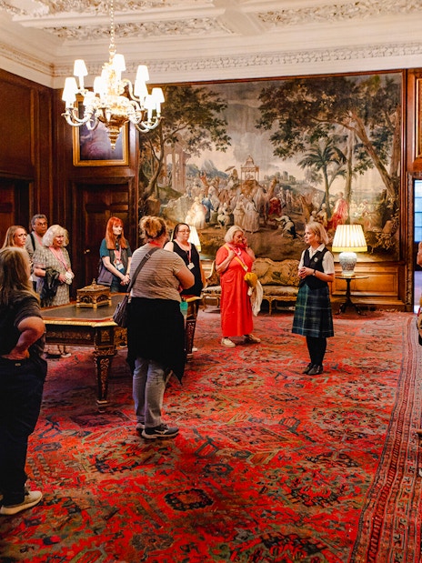 Guided group tour inside the ornate room of Palace of Holyroodhouse, Edinburgh.