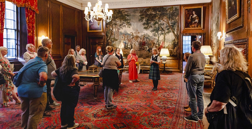 Guided group tour inside the ornate room of Palace of Holyroodhouse, Edinburgh.