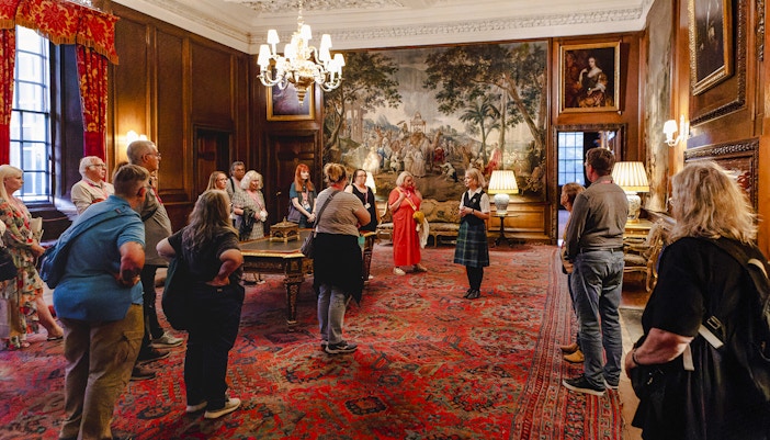 Guided group tour inside the ornate room of Palace of Holyroodhouse, Edinburgh.