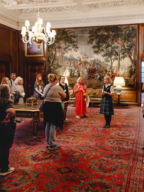 Guided group tour inside the ornate room of Palace of Holyroodhouse, Edinburgh.
