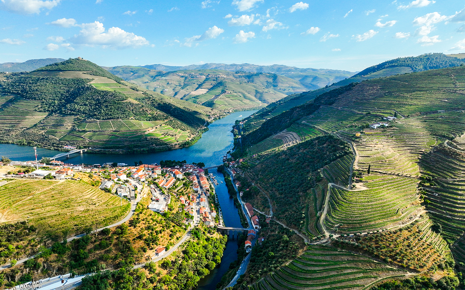 Aerial view of Pinhão village by Tua River with terraced vineyards in Portugal.