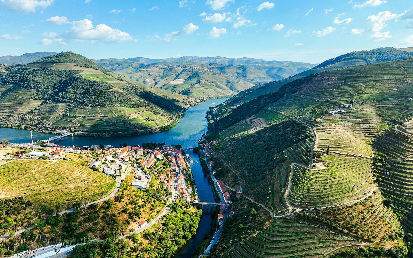 Aerial view of Pinhão village by Tua River with terraced vineyards in Portugal.