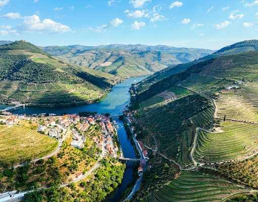 Aerial view of Pinhão village by Tua River with terraced vineyards in Portugal.