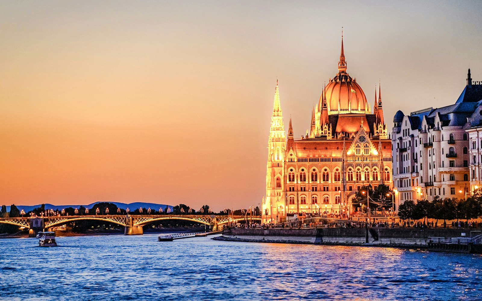 Budapest Danube River cruise with illuminated Parliament building at night.