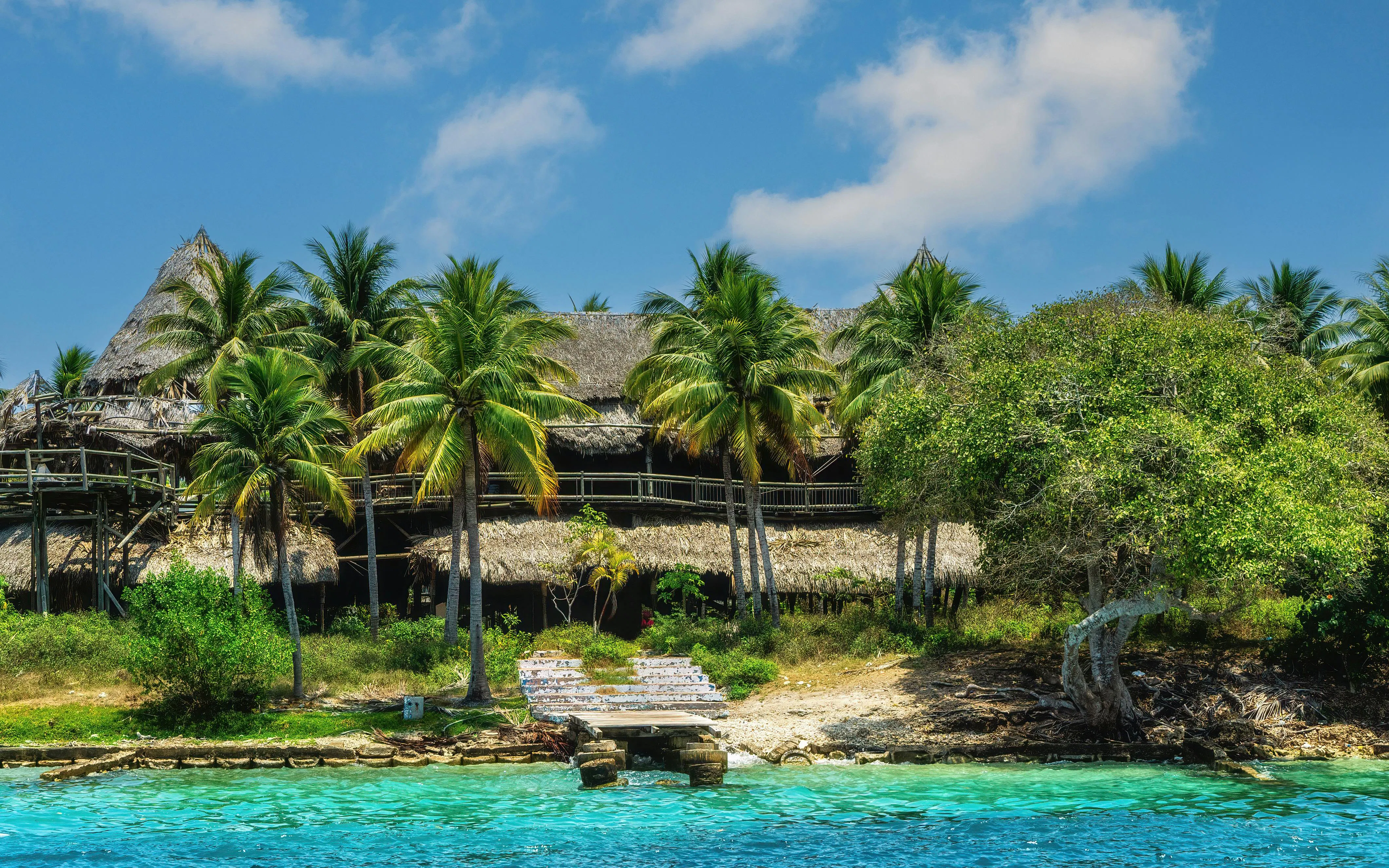 Thatch-roofed huts and palm trees on Rosario Islands, Caribbean coral reef near Cartagena, Colombia.