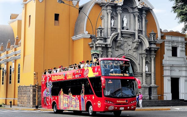 Double-decker bus in Lima, Peru, passing by historic buildings on a hop-on hop-off city tour.