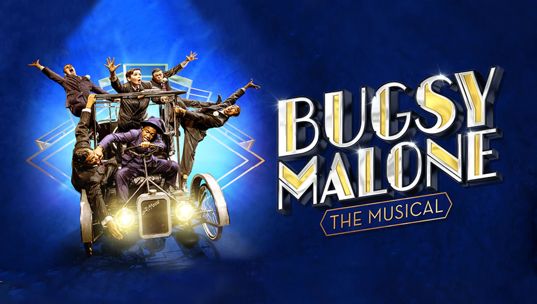 Cast of Bugsy Malone musical on vintage car against blue background