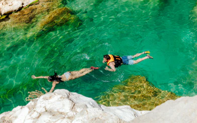 Guests swimming in clear waters of Wadi Shab, Oman.