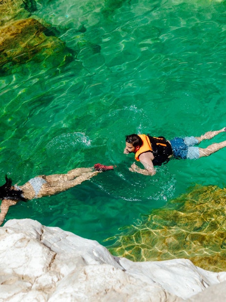 Guests swimming in clear waters of Wadi Shab, Oman.