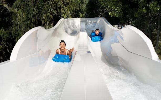 People tubing down water slide at Grand Hyatt waterpark, Dubai.