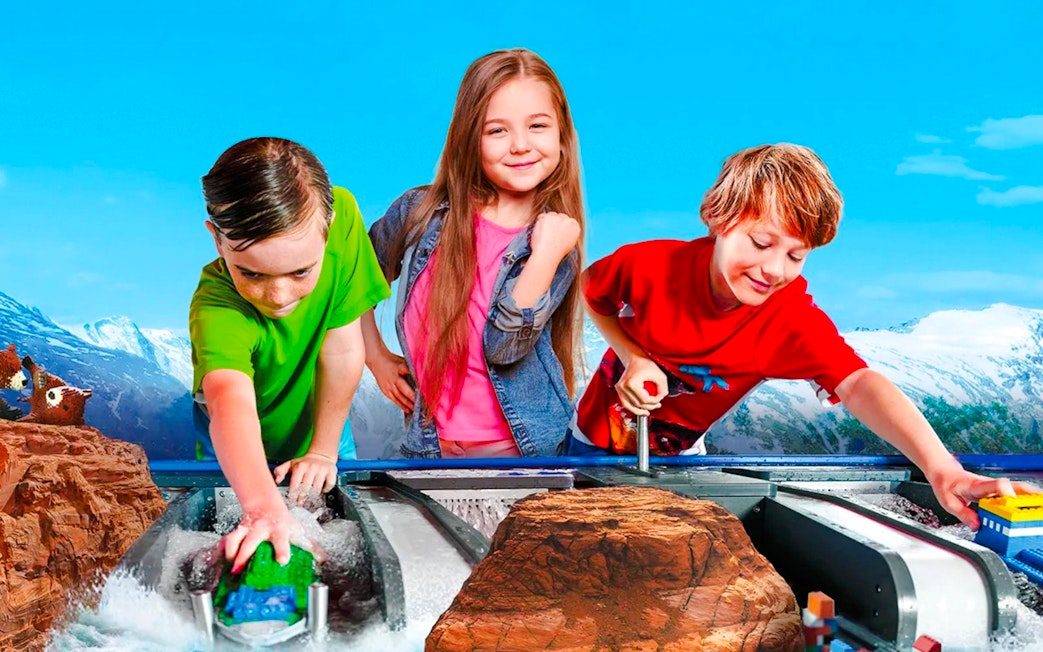 Children playing with LEGO boats at LEGOLAND Billund water ride.