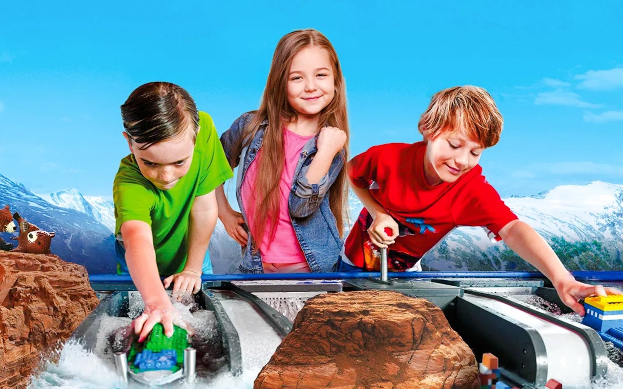 Children playing with LEGO boats at LEGOLAND Billund water ride.